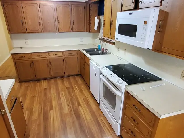 The same kitchen cleared and swept, counters and floor completely empty